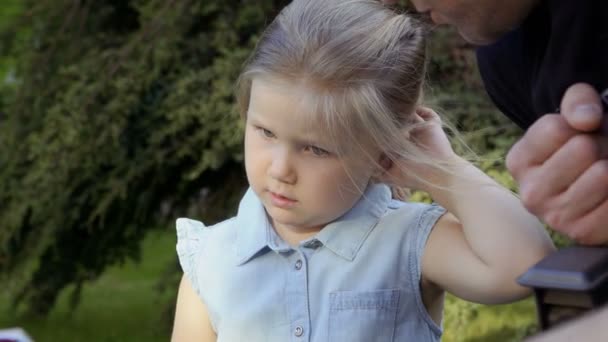 Padre lesse un libro alla figlioletta in giardino — Video Stock