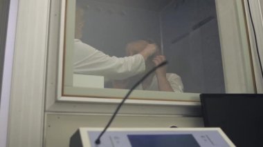 Doktor kulaklık üzerinde yetişkin kadın koyar.