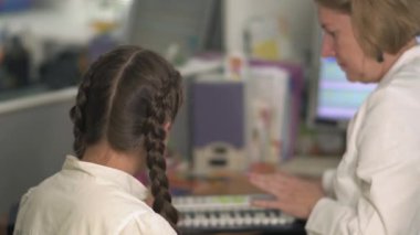 Surdopedagogs genç kız ile iletişim kurar.