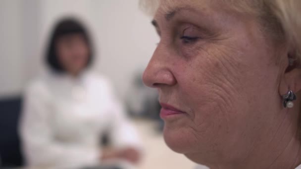 Взрослая женщина со слуховым аппаратом — стоковое видео