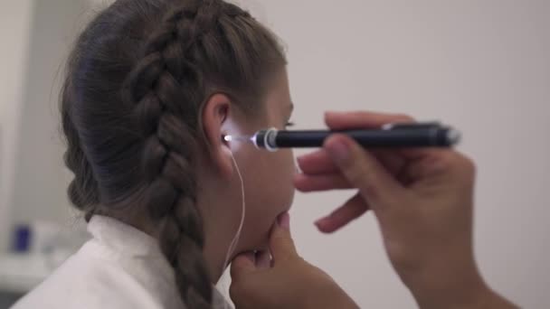 Enfermera examina el oído de una niña — Vídeo de stock