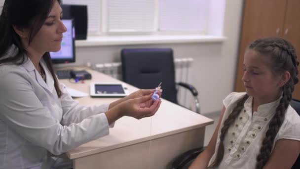 Le médecin montre les aides auditives fille . — Video