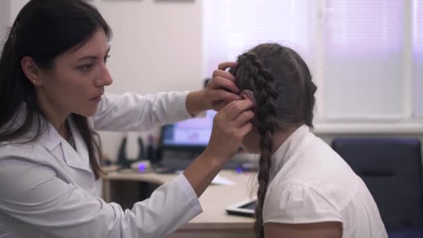 Enfermeira examina o ouvido de uma menina — Vídeo de Stock