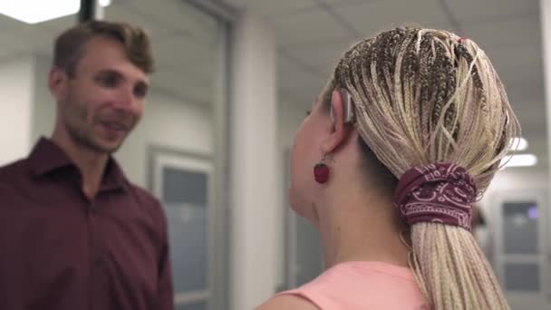 Knappe jongen knuffelen van een mooi meisje in de gang van een medisch centrum. — Stockvideo