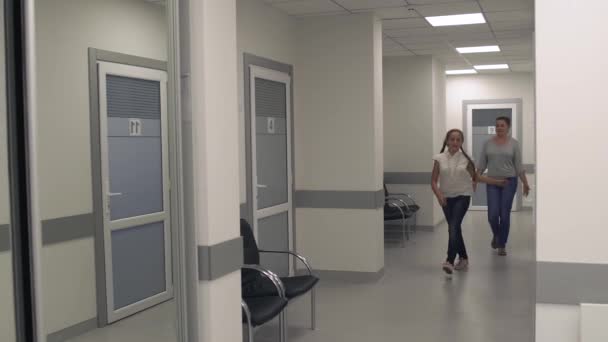 Teen girl skips along the corridor of the medical center — Stock Video