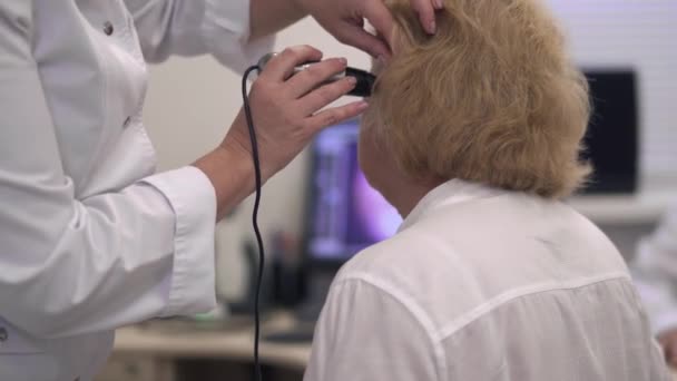 Krankenschwester untersucht Ohr einer erwachsenen Frau. — Stockvideo