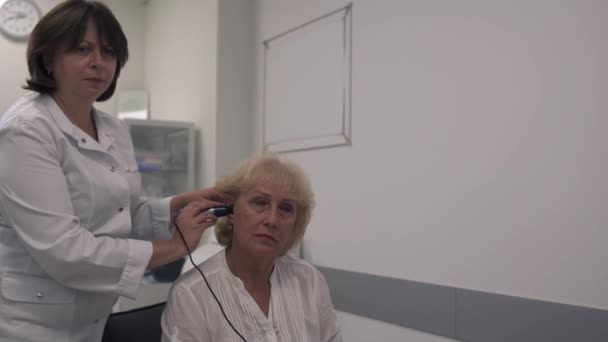 Ιατρικό επαγγελματία δοκιμές το αυτί μιας ενήλικης γυναίκας — Αρχείο Βίντεο