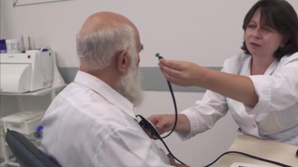 Médico profesional examina el oído de un hombre adulto — Vídeo de stock