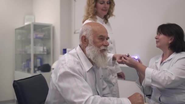 Medical professional tests the ear of an adult man — Stock Video