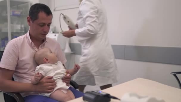 Στοργικός πατέρας κρατά την μικρή κόρη του στην αγκαλιά στο νοσοκομείο — Αρχείο Βίντεο