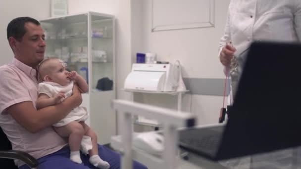 Liebender Vater hält seine kleine Tochter im Krankenhaus in den Armen — Stockvideo