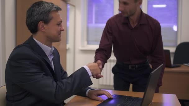 Deux hommes d'affaires à une table devant un ordinateur portable — Video