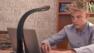 Genç adam dizüstü bilgisayar ve cep telefonu üzerinde tıklayarak