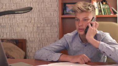 Oğlan yatak odasında telefonla konuşuyor