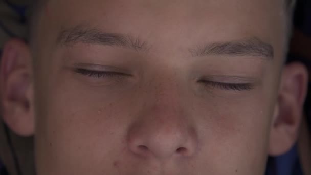 Knappe jongen opent zijn ogen in de ochtend — Stockvideo