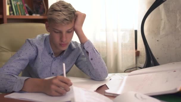 El chico está estudiando en casa. — Vídeos de Stock