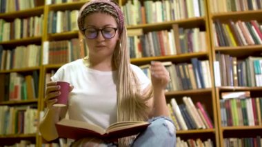 Güzel kız kütüphanede kitap okuma