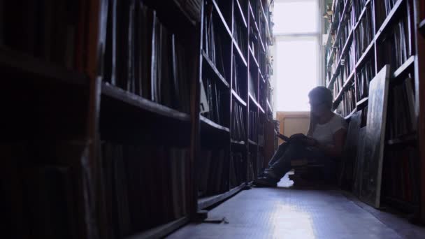 Vacker flicka mellan raderna med böcker i biblioteket — Stockvideo