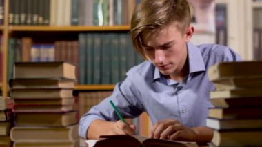 Kütüphanede masadaki genç yakışıklı adam