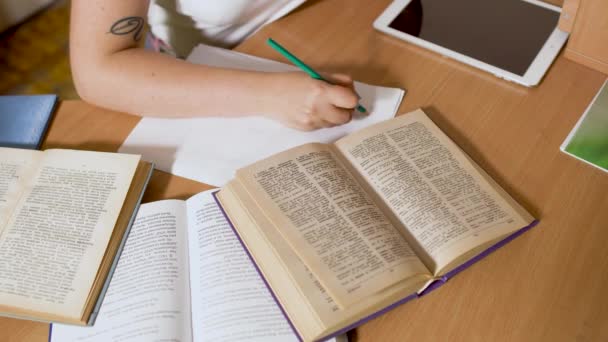 Meisje is schrijven met een potlood aan een tafel — Stockvideo