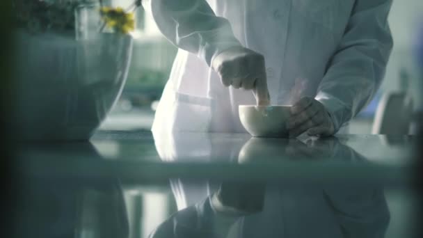 Фармацевт подрібнює препарат у білій тарілці — стокове відео