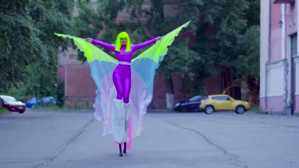 Girl on stilts in violet clothing dance on the street — Stock Video