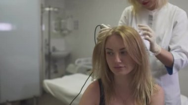 Dermatolog kızın kafasına cilt inceliyor