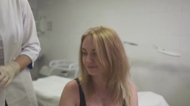Dermatolog kızın kafasına cilt inceliyor