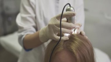 Dermatolog kızın kafasına cilt inceliyor