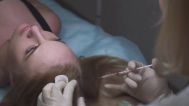 Güzel kız Mezoterapi saç için alır.