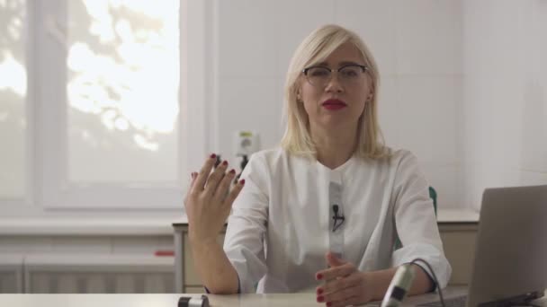 Hermosa chica dermatóloga da una entrevista en el lugar de trabajo . — Vídeos de Stock