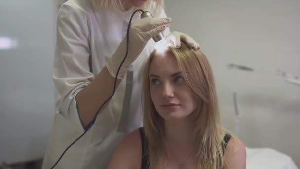 Dermatologist examines the skin on the head of the girl — Stock Video