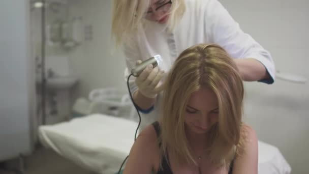 Dermatoloog onderzoekt de huid op het hoofd van het meisje — Stockvideo