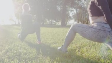 İki güzel kız parkta sabah egzersizleri yapıyor