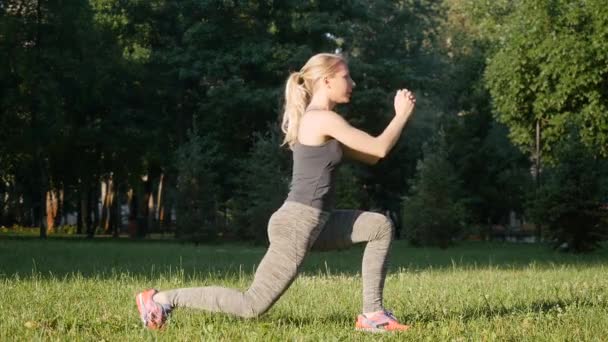 Vacker flicka gör övningar i parken — Stockvideo