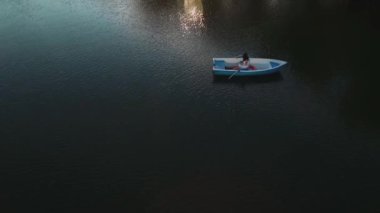 Genç kız göl bir teknede kürek