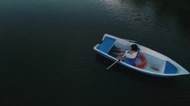 Genç kız göl bir teknede kürek