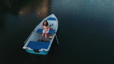 Kız bir teknede oturur ve saç düzeltir