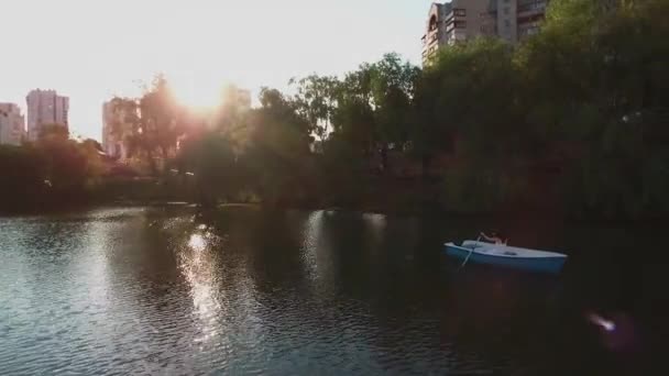 Jovem remo em um barco no lago — Vídeo de Stock