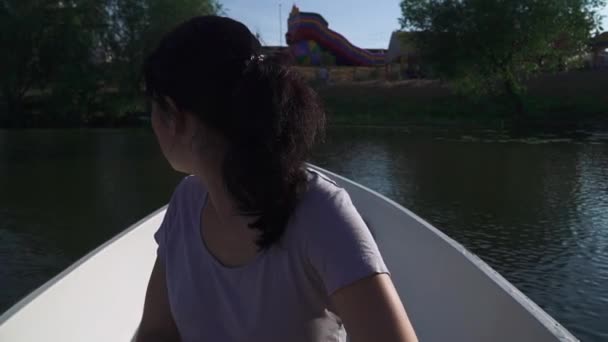 Schönes Mädchen rudert auf einem Boot auf dem See — Stockvideo