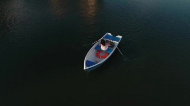 Genç kız bir teknede oturuyor