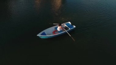 Genç kız bir teknede oturuyor