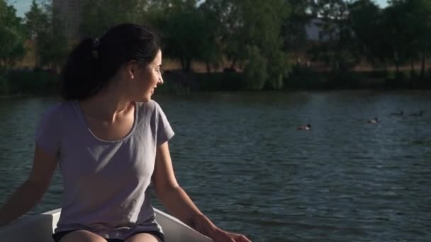 Красивая девушка сидит в лодке — стоковое видео