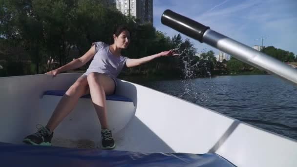 Belle fille saupoudre l'eau du bateau — Video