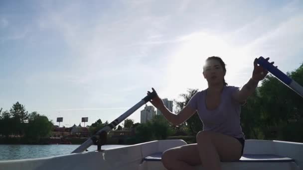 Beautiful girl smiles and enjoys rowing — Stock Video