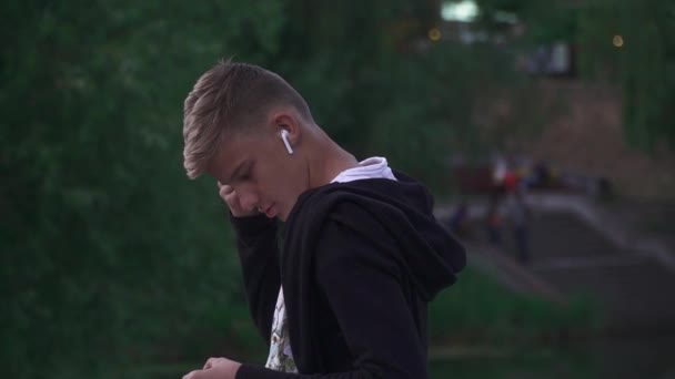 Młody facet z bezprzewodowych słuchawek — Wideo stockowe