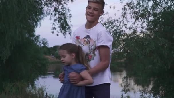 Jeune homme encerclé une petite fille près de la rivière — Video