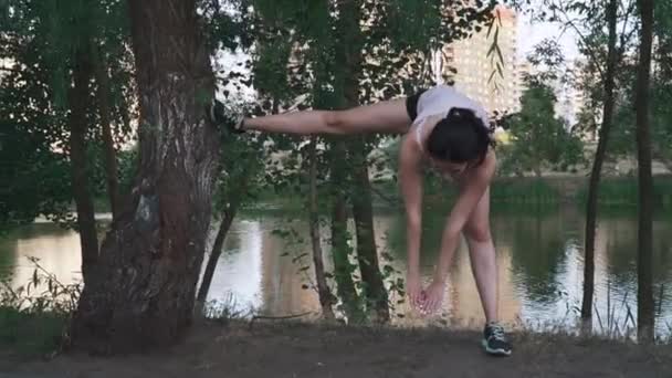 Young sportswoman doing exercise outdoors — Stock Video