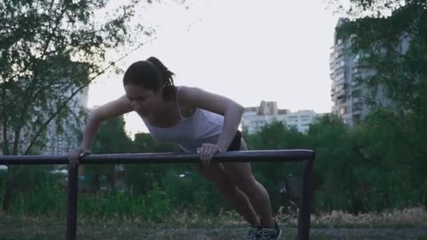 Young sportswoman doing exercise outdoors — Stock Video