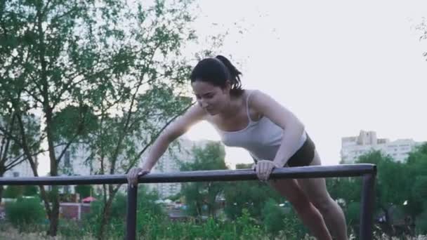 Young sportswoman doing exercise outdoors — Stock Video